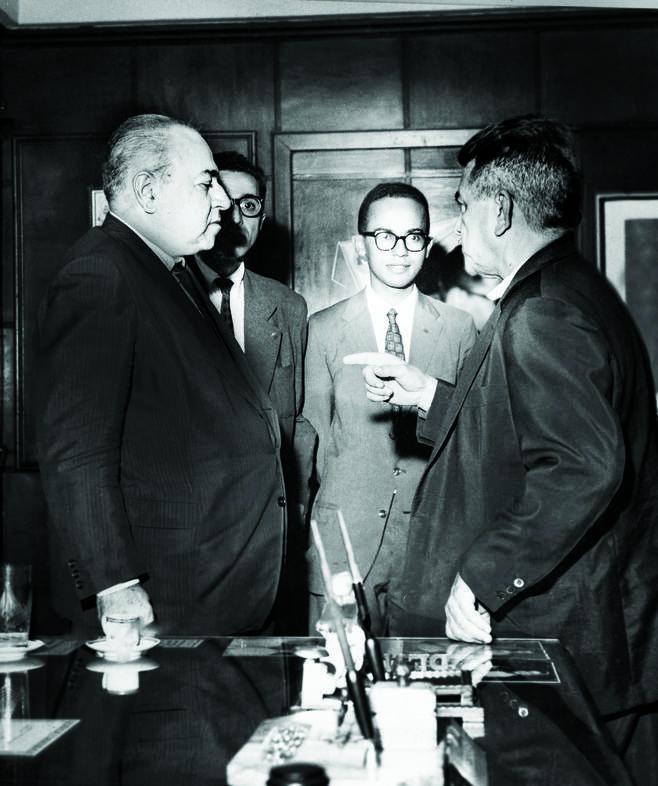 Em meio aos veteranos Legionários dr. Mário da Cruz (de óculos, à esquerda) e dr. Osmar Carvalho e Silva (à direita), que dialogam com o Fundador da LBV, Alziro Zarur (1914-1979), destaca-se o jovem José de Paiva Netto, aos 20 anos, sempre atento aos rumos da Instituição. O registro foi feito em 1963, no gabinete da Presidência da antiga Rádio Mundial, naquela época a Emissora da Boa Vontade, no Rio de Janeiro/RJ.